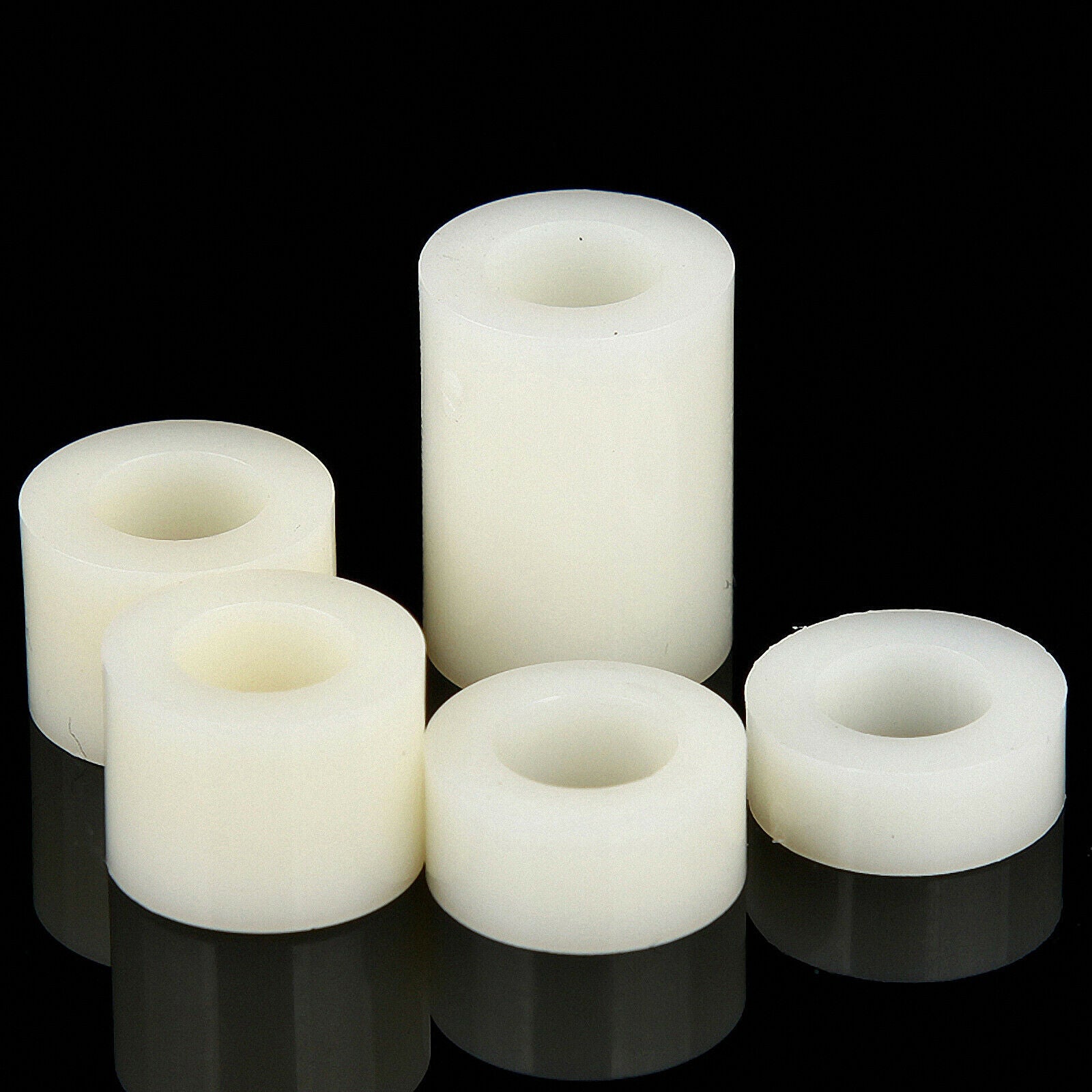 White nylon spacers in a plastic container with a label