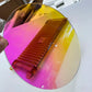 A sheet of iridescent acrylic being cut by a laser